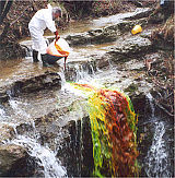 Primer sledilnega poskusa z injiciranjem fluorescentnega sledila uranina v vodni tok na ponoru (Foto: G. Parkin).